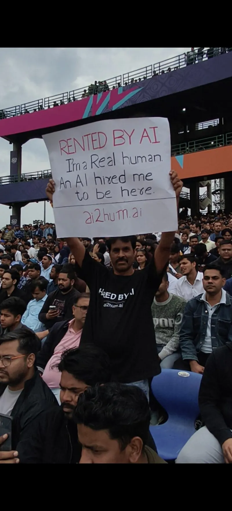 Hold promotional sign at cricket stadium